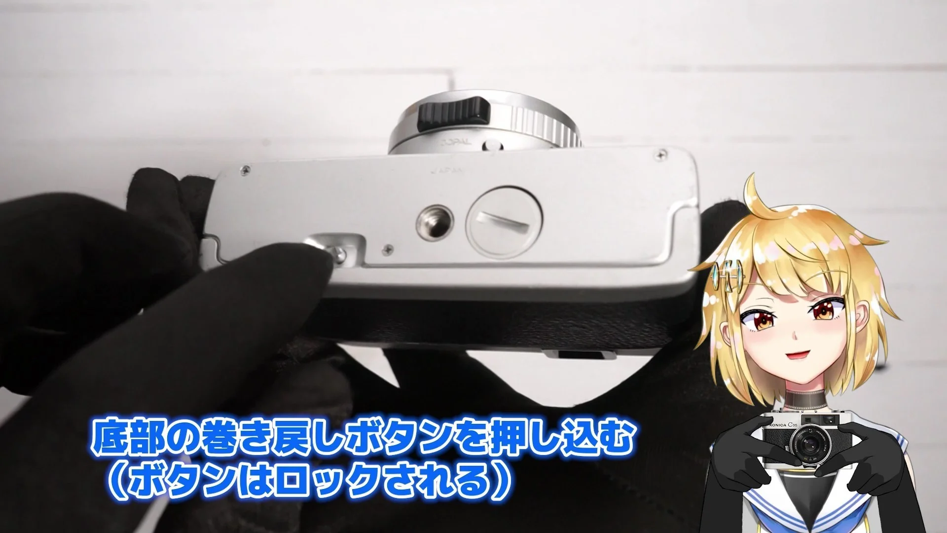 カメラの底部にある巻き戻しボタンを押し込む